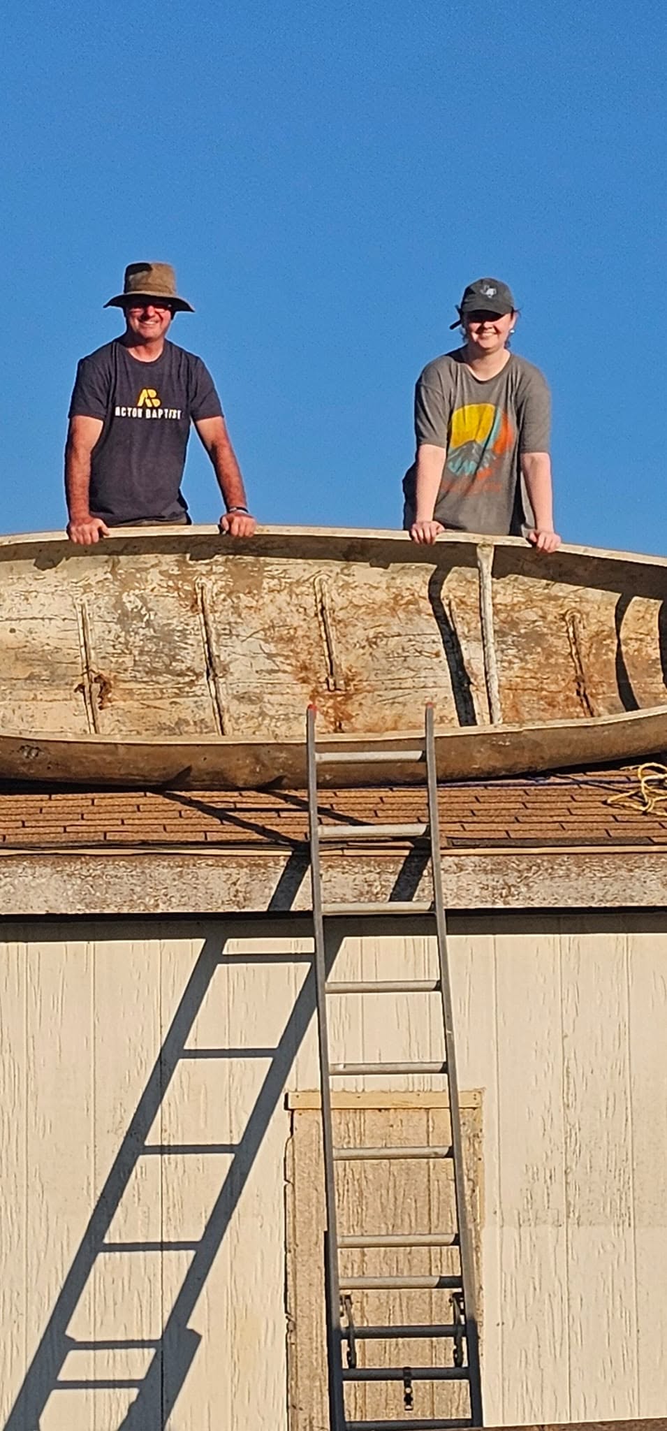Two people standing behind wooden construction forms outdoors.