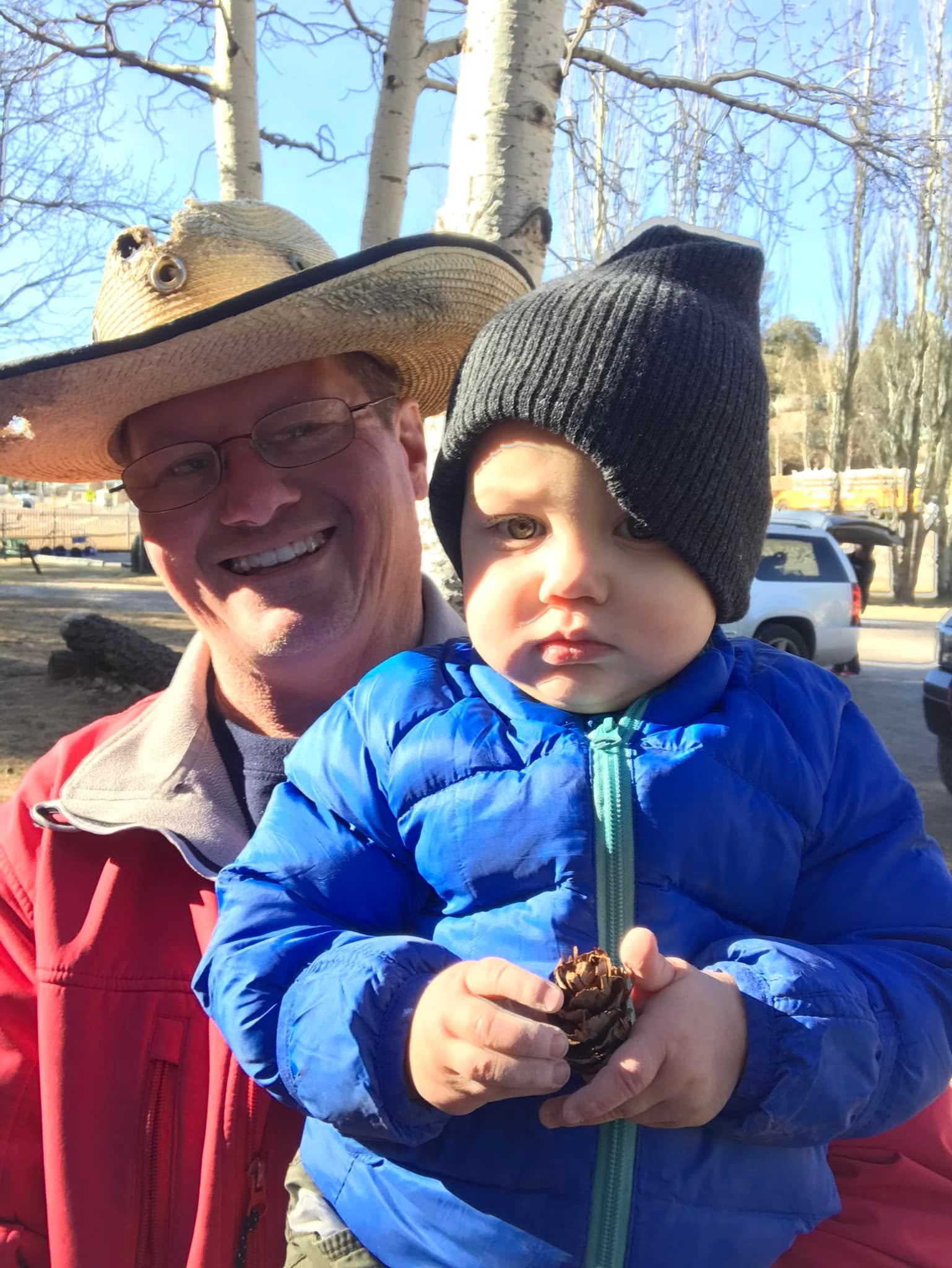 An adult and a young child bundled up outdoors.