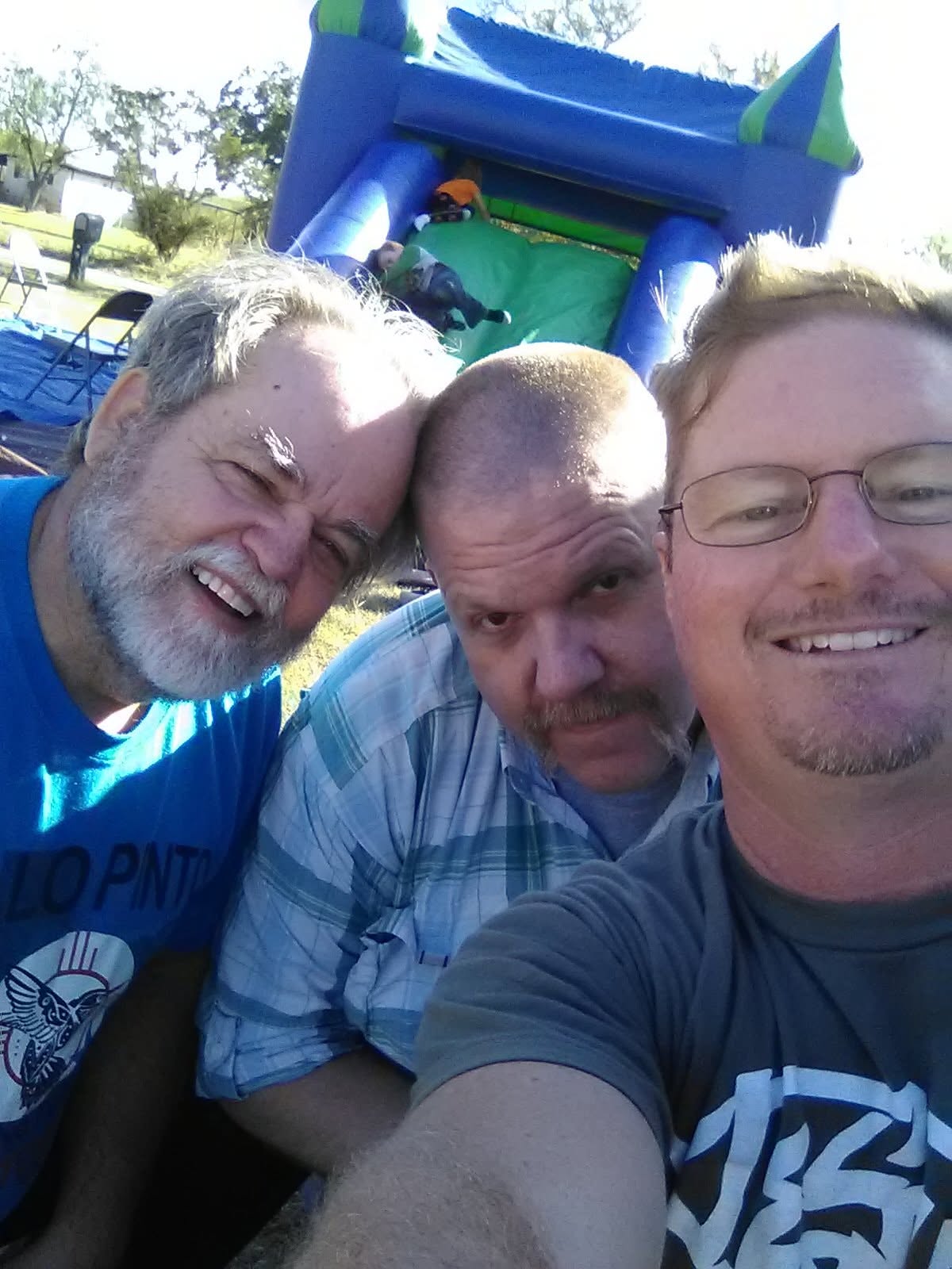 Three people taking a selfie at an outdoor gathering.
